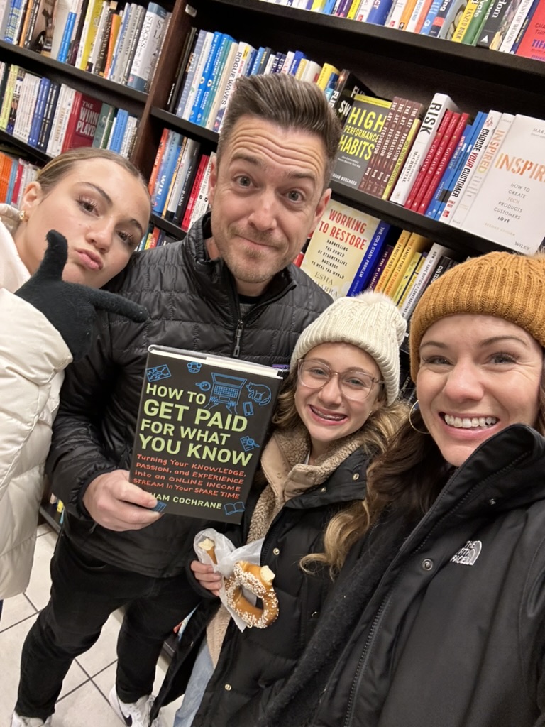 Graham Cochrane holding How to Get Paid for What You Know at a bookstore